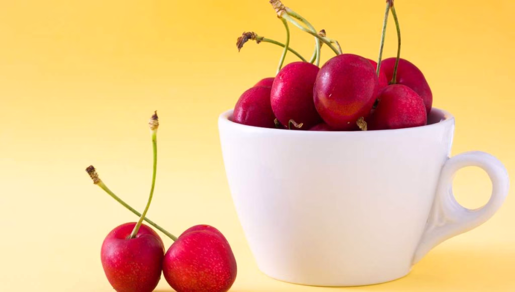 Fresh red cherries in a white cup